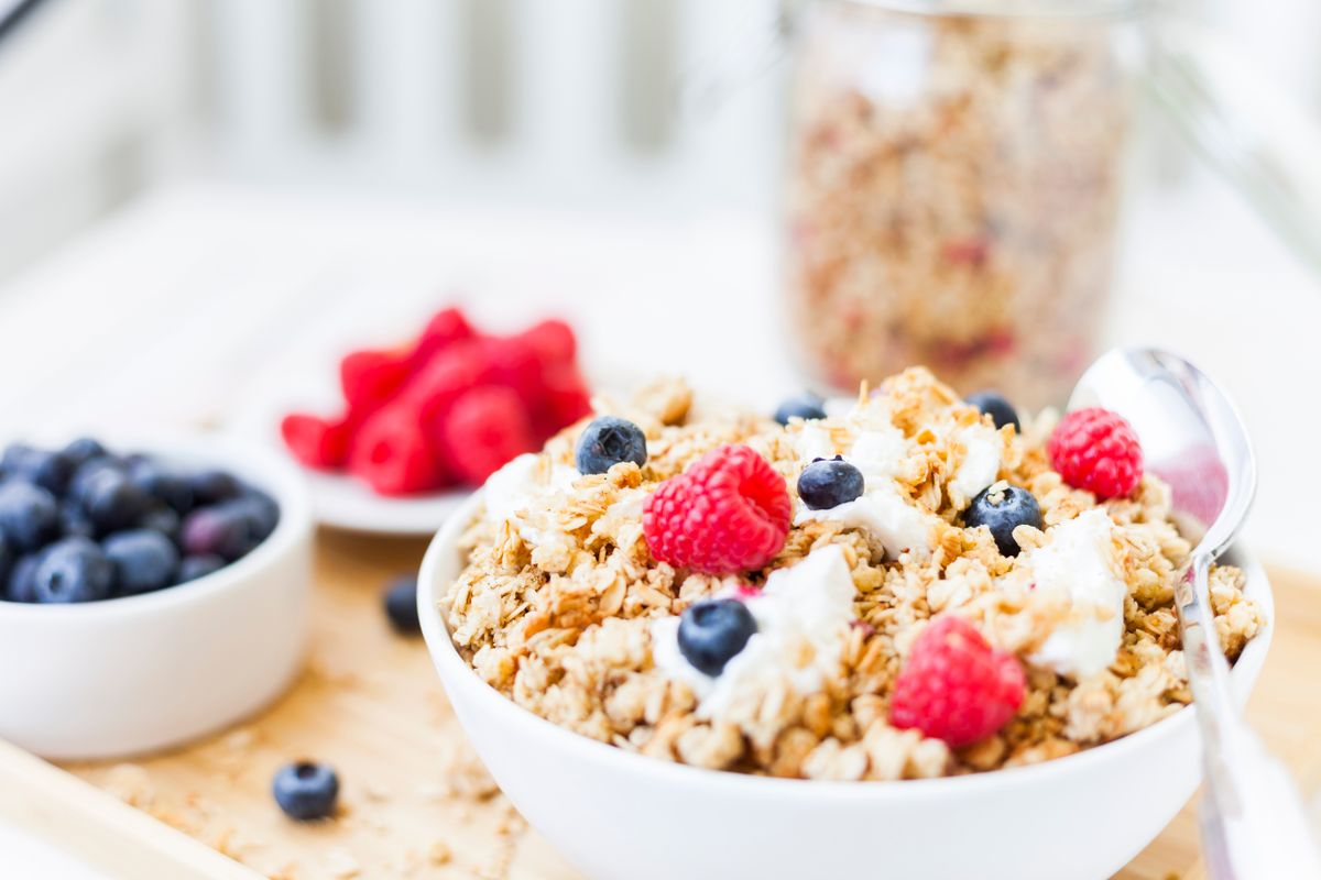 Granola breakfast bowl topped with fresh berries.