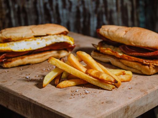 Fried egg sandwiches in bread rolls served on a wooden board