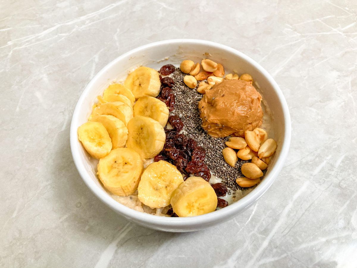 Breakfast bowl with bananas, chia seeds, peanuts, and peanut butter.