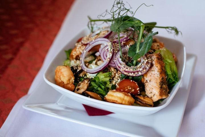 Delicious seafood salad with salmon and shrimp, garnished with fresh greens and onions.