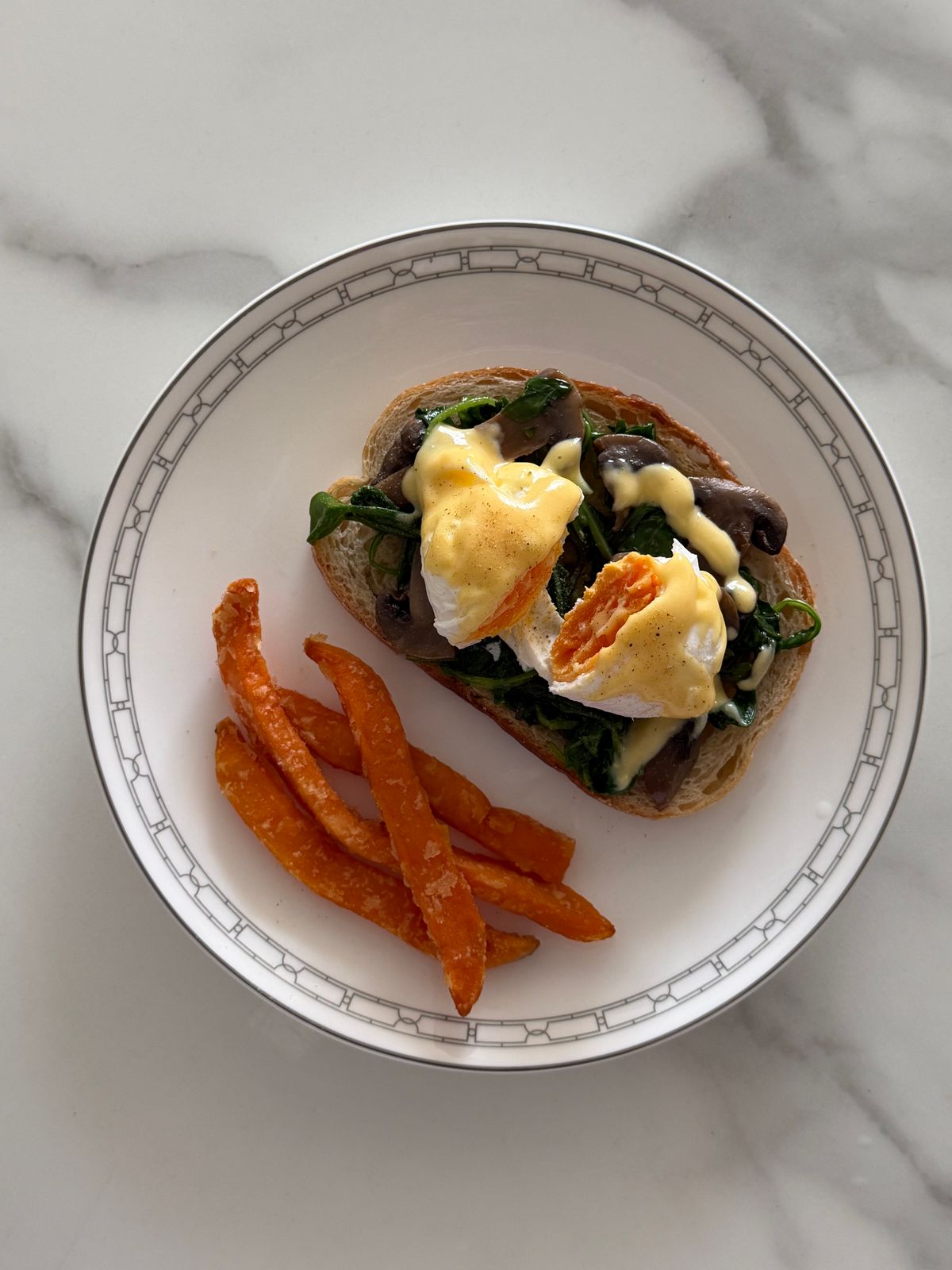 Eggs Benedict served with sweet potato fries.