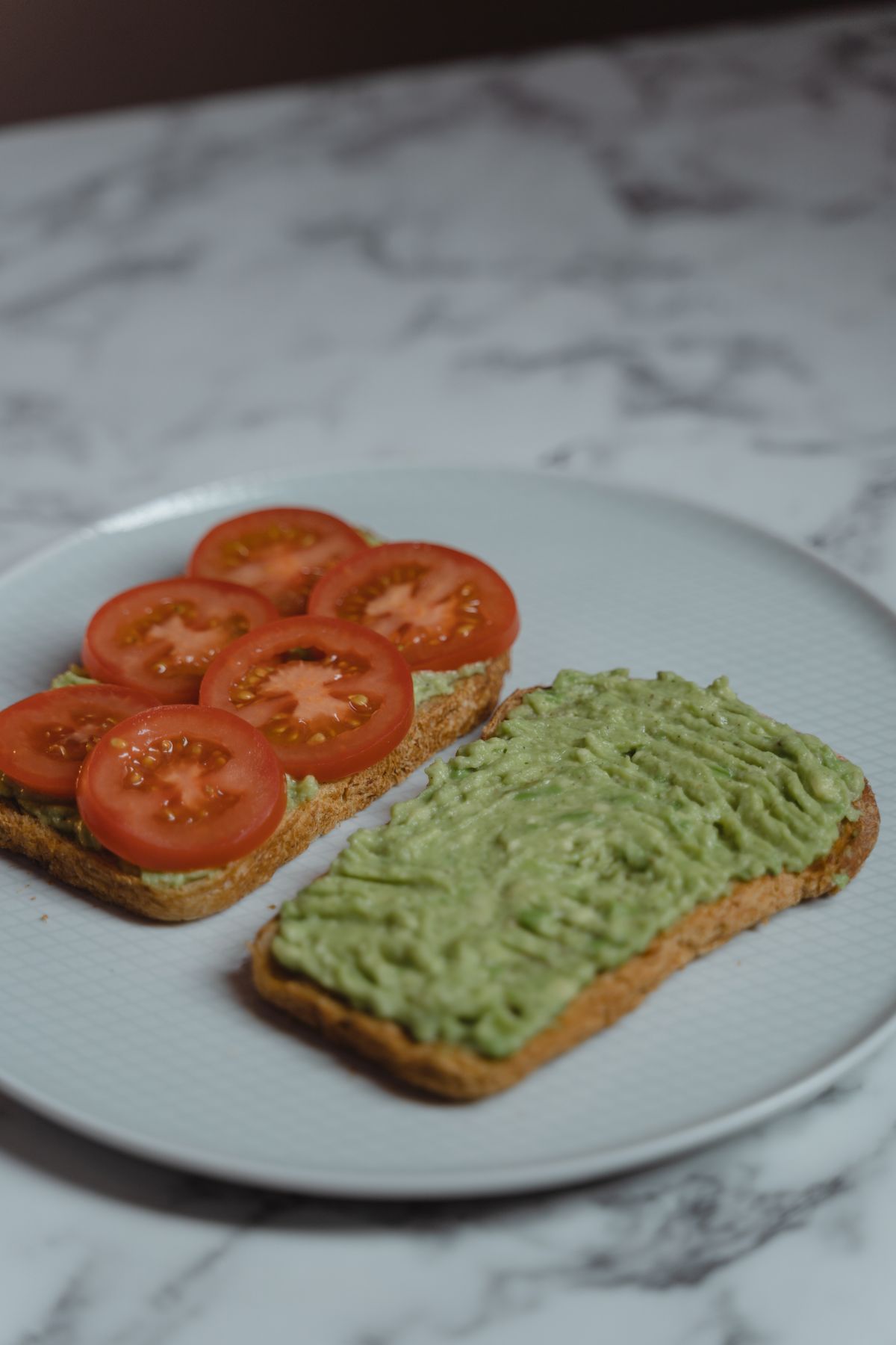 Toast topped with sliced tomato and creamy avocado.
