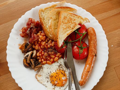 Full English breakfast plate with baked beans, toast, egg, sausage and tomato