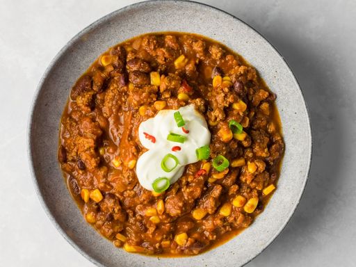 Chili con carne with beans, corn and sour cream garnish
