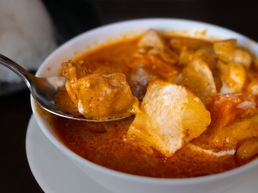 Bowl of chicken and potato curry in a rich sauce