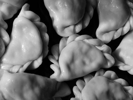 Monochrome close-up of homemade pinched dumplings (varenyky style)