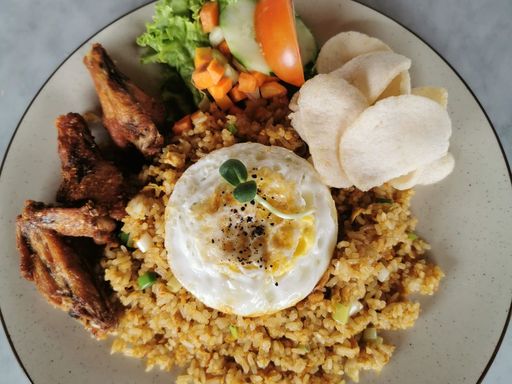 Nasi goreng with fried chicken, egg, and vegetables.