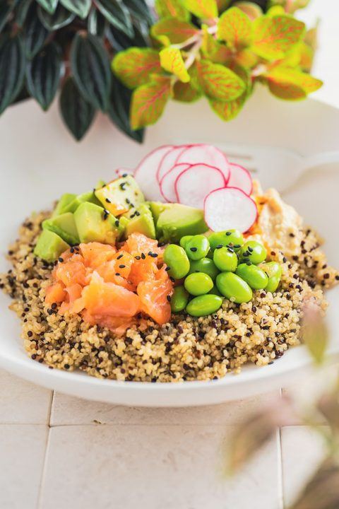 Vibrant quinoa salad topped with salmon, avocado, edamame, and radishes.