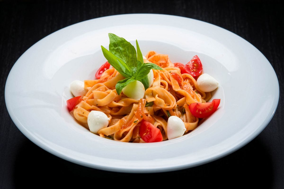 Italian pasta with tomatoes, mozzarella, and basil.