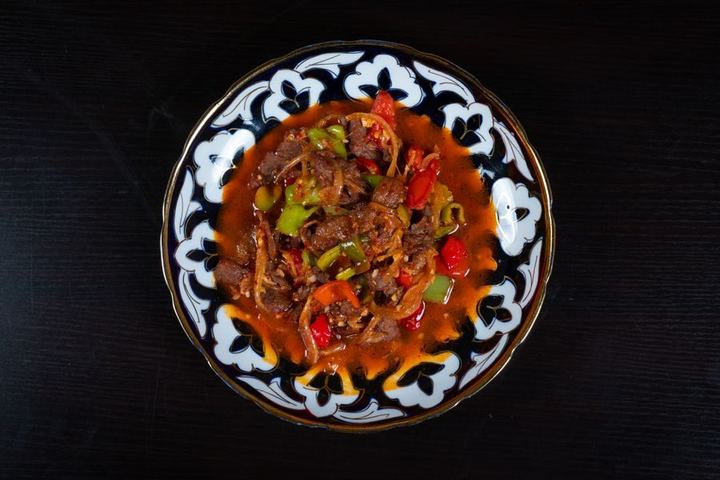 Delicious beef stew with vibrant vegetables in a decorative bowl.