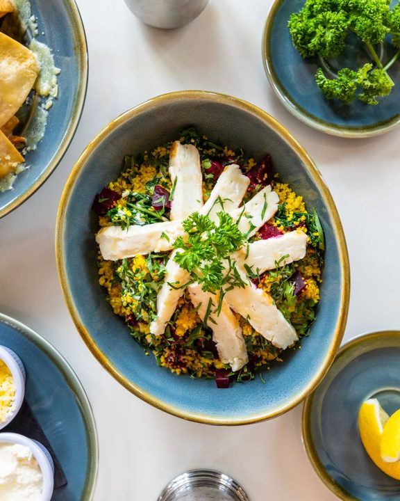 Delicious quinoa salad topped with cheese slices and fresh herbs, perfect for a nutritious