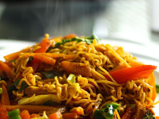 Hot chow mein noodles served on a white ceramic plate.