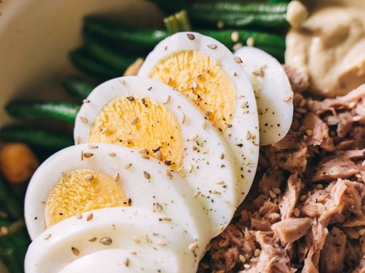 Fresh tuna salad with sliced eggs, green beans, and seasoning.