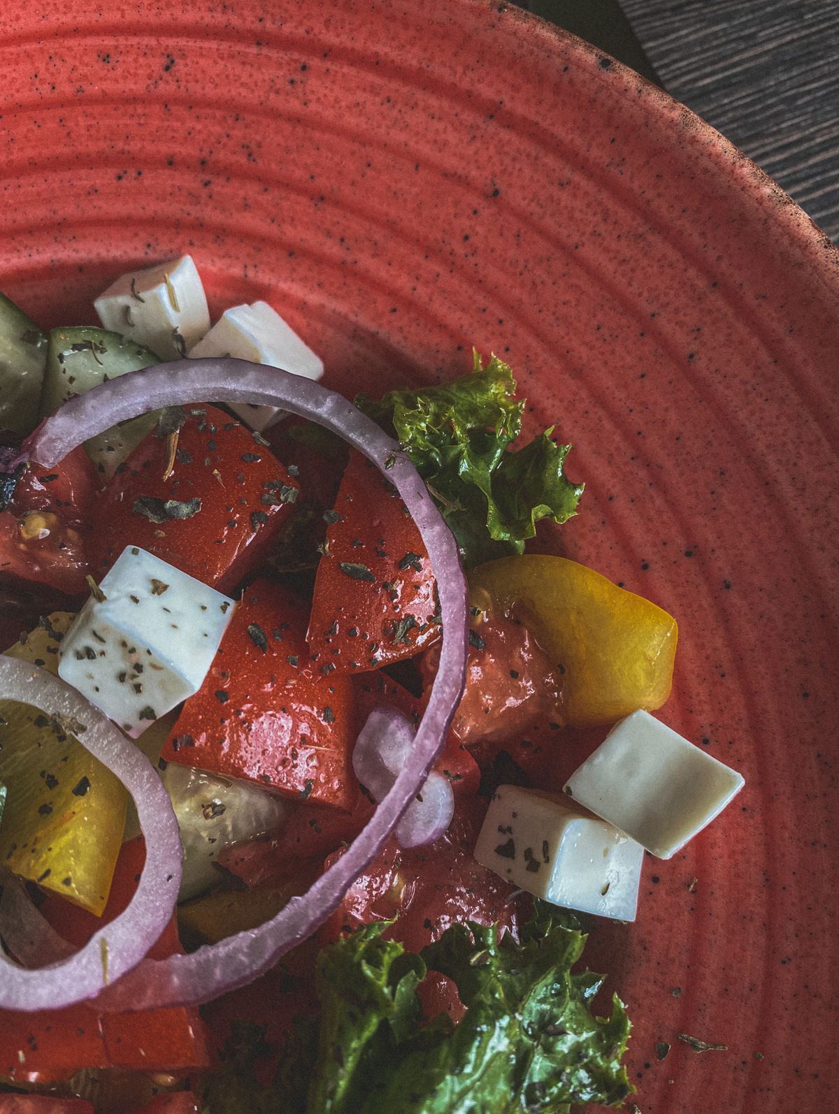 Greek salad with fresh vegetables, feta cheese, and herbs.