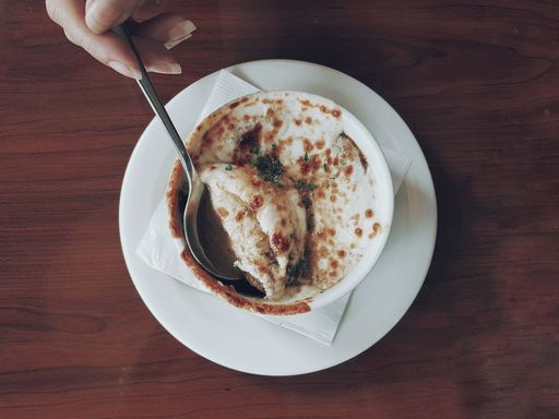 French onion soup with melted cheese served in a ceramic bowl.