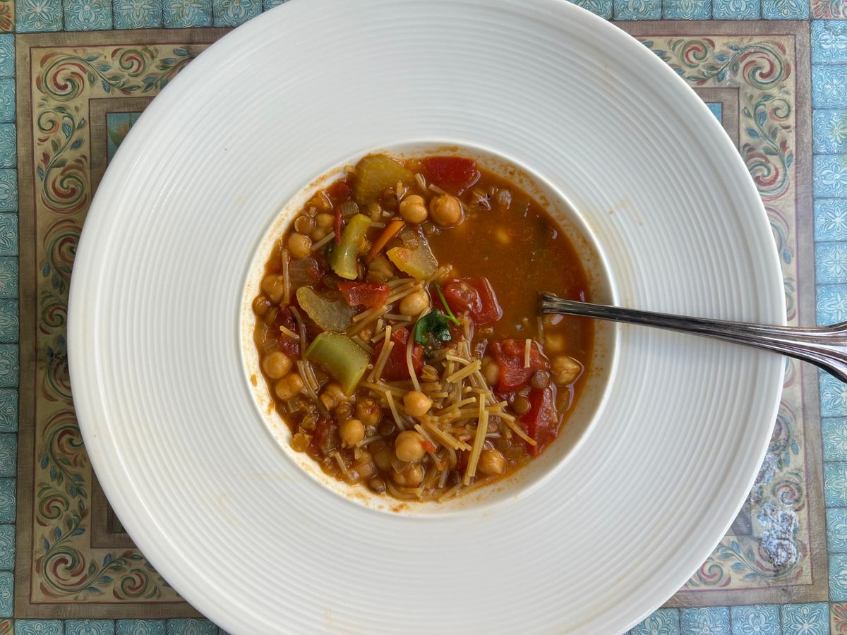 Chickpea soup served in a white bowl.