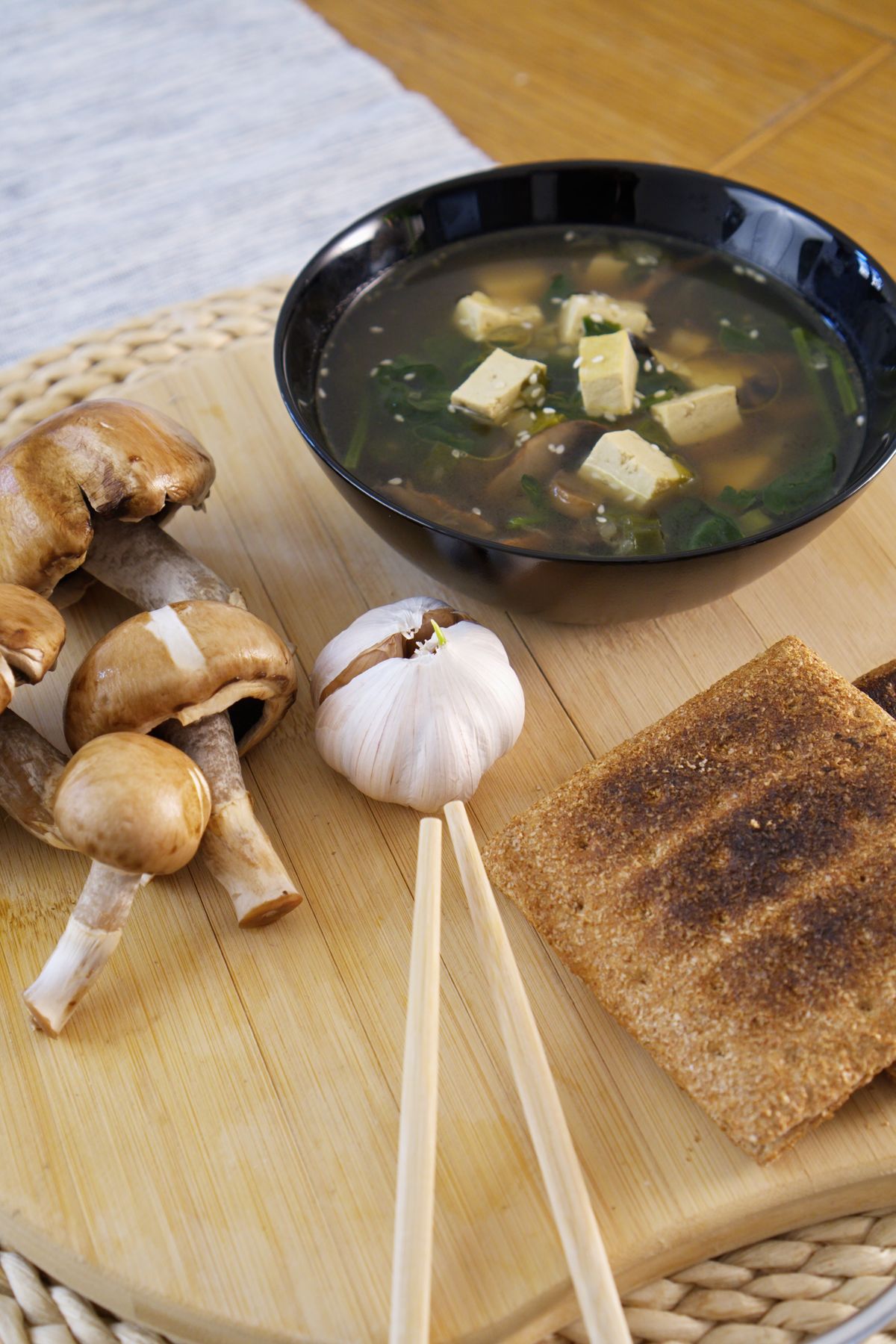 Vegan miso soup with tofu, mushrooms, garlic, and bread.