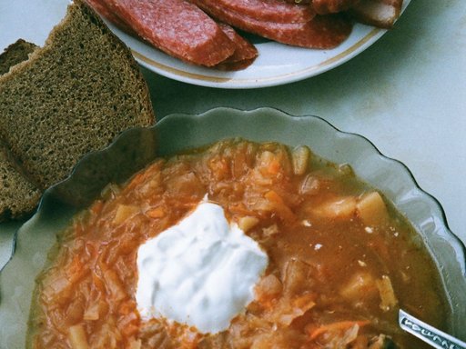 Homemade cabbage soup in a bowl with sour cream