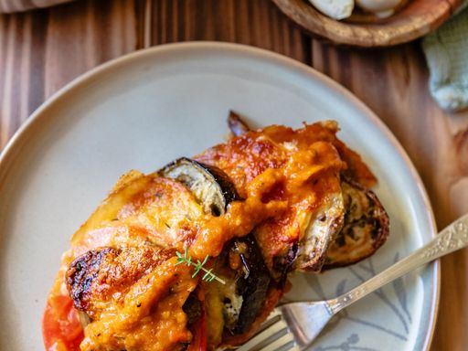 Savory ratatouille served on a ceramic plate with fresh garlic garnish.