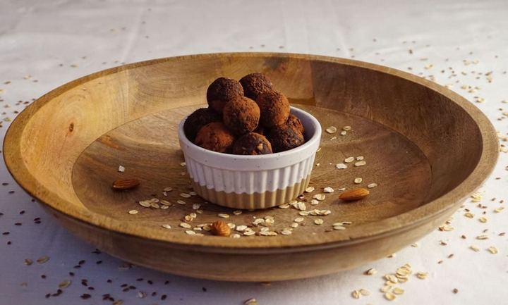 Homemade chocolate energy bites in a wooden bowl, perfect for healthy snacking.