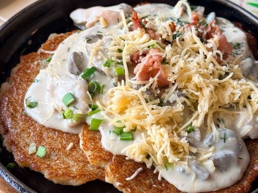 Traditional draniki (potato pancakes) with creamy mushroom topping