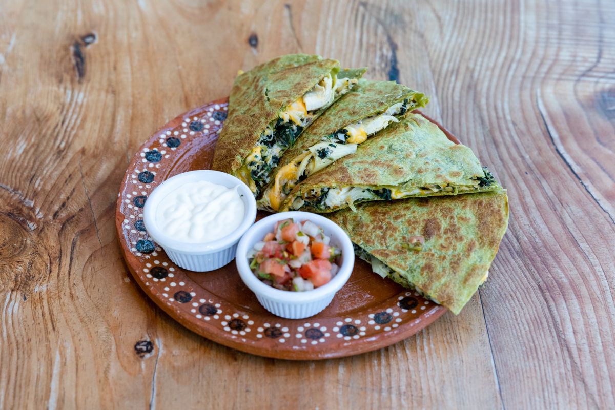 Spinach and cheese quesadilla served with salsa and cream.
