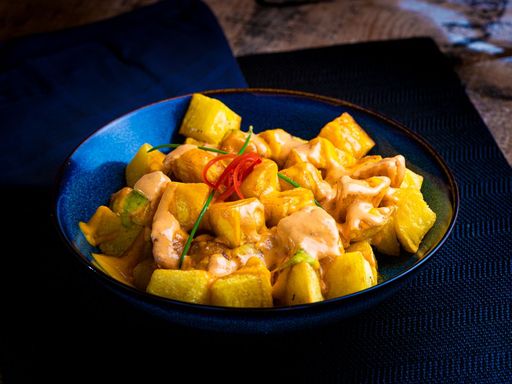 Patatas bravas in a blue ceramic bowl